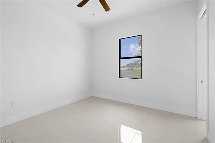 Tiled empty room featuring ceiling fan
