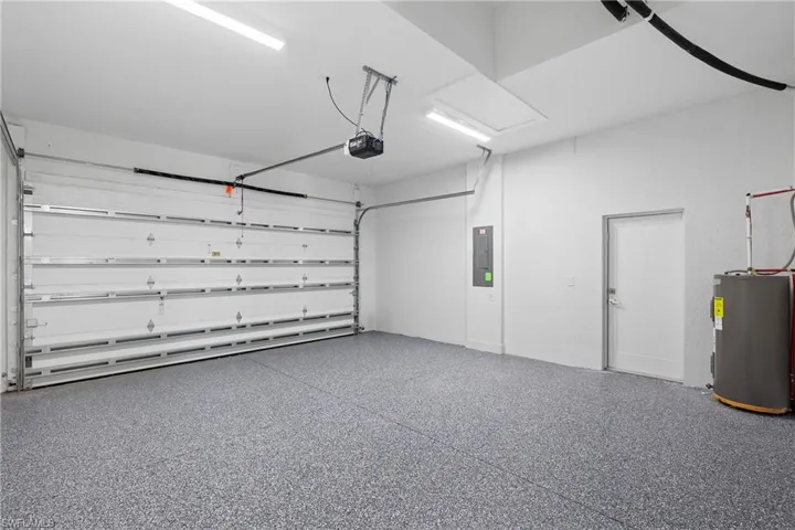 Garage featuring a garage door opener and water heater