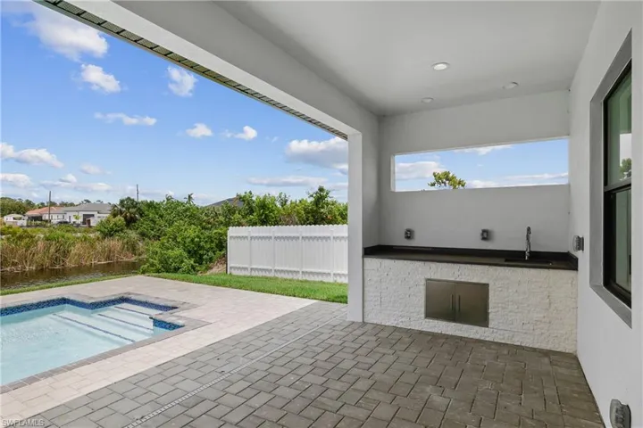 View of terrace featuring sink and a fenced in pool