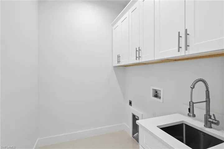 Laundry area featuring cabinets, sink, hookup for an electric dryer, and hookup for a washing machine