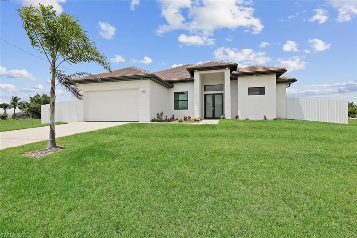 Prairie-style home with a garage and a front lawn