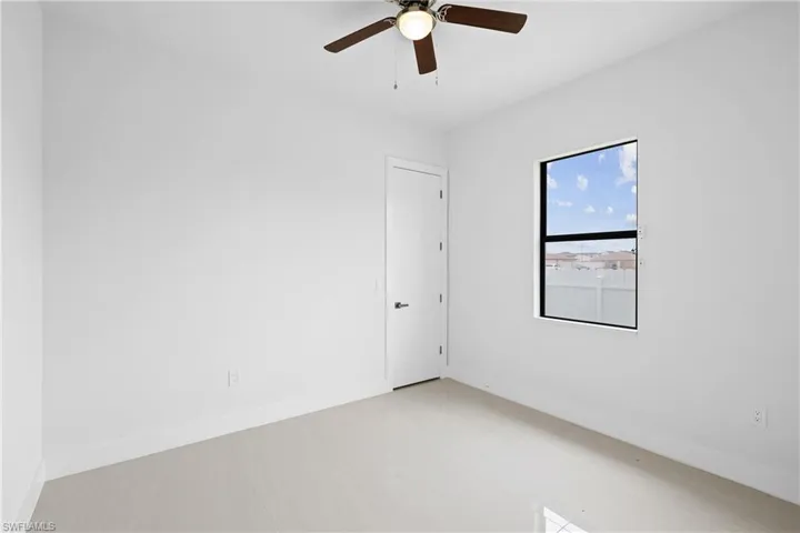Empty room with tile floors and ceiling fan