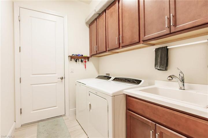 LAUNDRY ROOM WITH PLENTY OF CABINETS & A SINK.