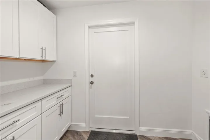 The laundry room has matching kitchen countertops with top and lower storage which doubles as a pantry area.