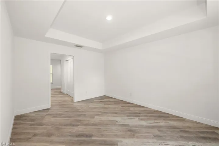 The primary bedroom has a tray ceiling, a pocket door leading toward the bathroom, and dual closets. One standard style and the other is a huge walk in closet!