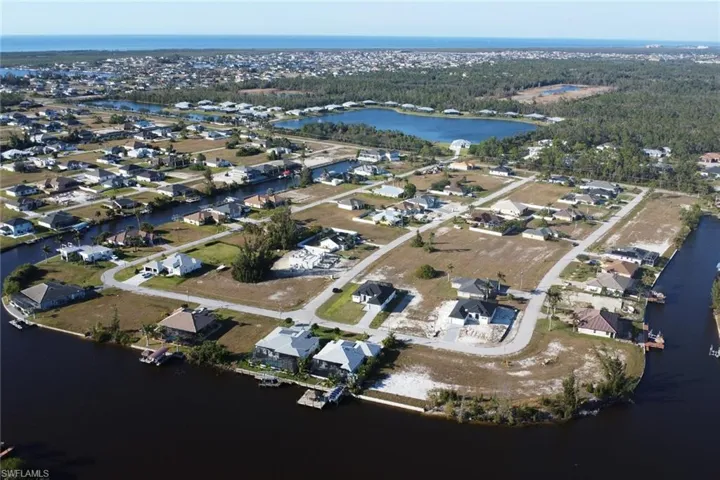 Aerial overview of property's location featuring a nearby body of water and nearby suburban area