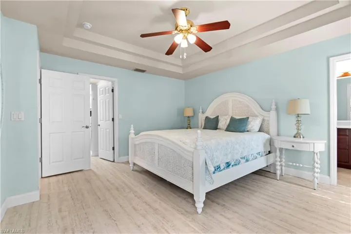Living area with arched walkways, a ceiling fan, wood finished floors, and high vaulted ceiling