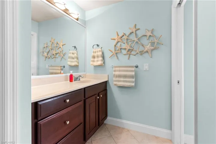 Primary bedroom with a double tray ceiling, large custom walk-in closet and plantation shutters