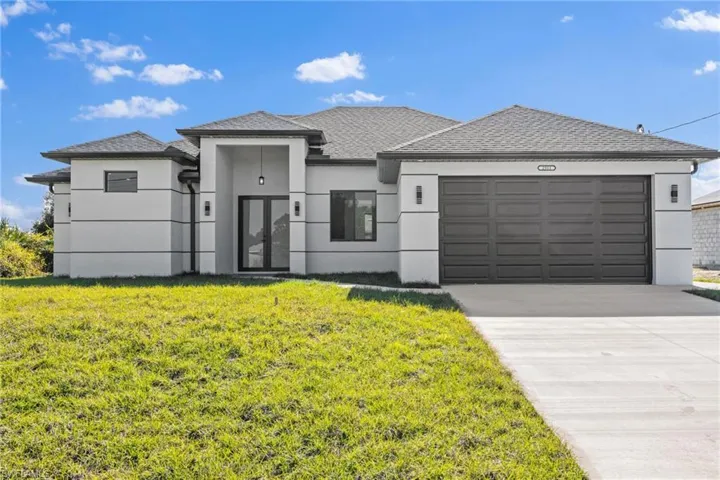 View of front of property with a front yard and a garage