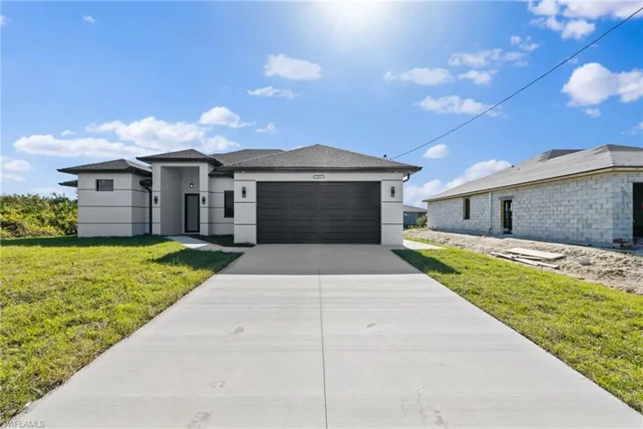 View of front of home with a garage and a front yard