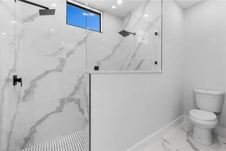 Bathroom with toilet and tiled shower