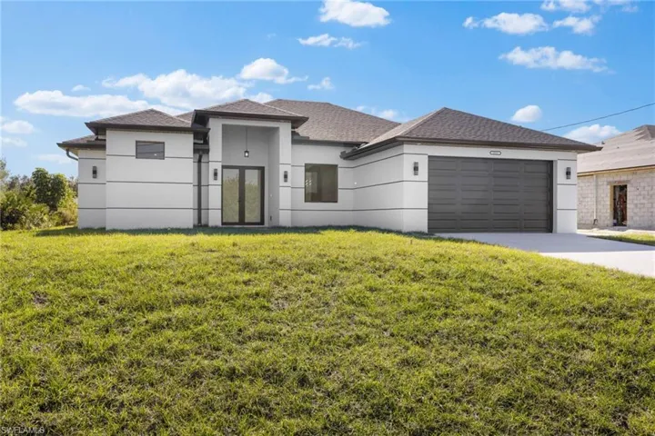 View of front of home featuring a garage and a front lawn