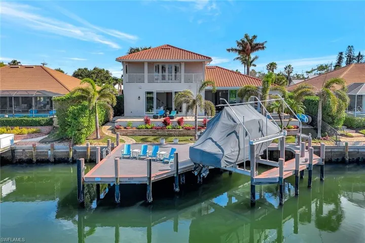 View of dock with a balcony, a water view, and a patio area