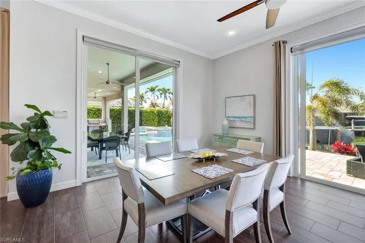 Dining room with crown molding, wood-type flooring, and ceiling fan