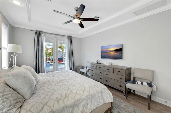 Bedroom featuring crown molding, hardwood / wood-style flooring, ceiling fan, access to outside, and french doors