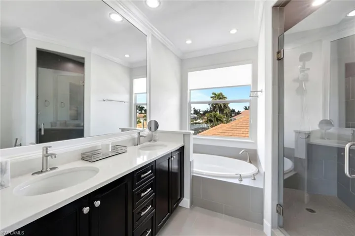 Bathroom featuring crown molding, vanity, separate shower and tub, and tile patterned flooring