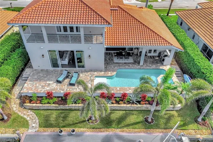 Back of house featuring a balcony, a yard, and a patio area