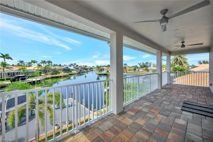 Balcony featuring a water view and ceiling fan
