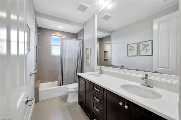 Full bathroom featuring shower / bath combo, vanity, tile patterned floors, and toilet