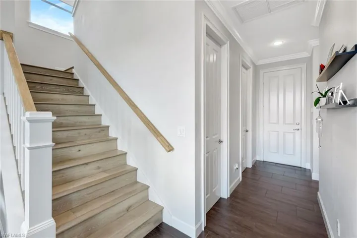 Stairway featuring crown molding and hardwood / wood-style flooring