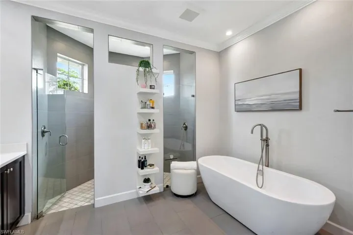 Bathroom featuring shower with separate bathtub, ornamental molding, and vanity