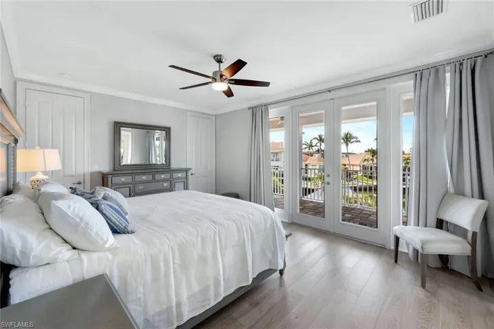 Bedroom with wood-type flooring, access to outside, ceiling fan, crown molding, and french doors