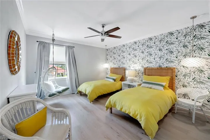 Bedroom with crown molding, light hardwood / wood-style floors, and ceiling fan