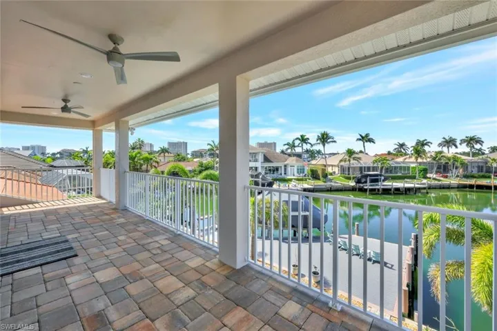 Balcony featuring a water view and ceiling fan