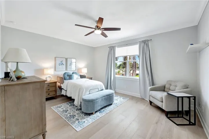 Bedroom featuring crown molding, ceiling fan, and light wood-type flooring