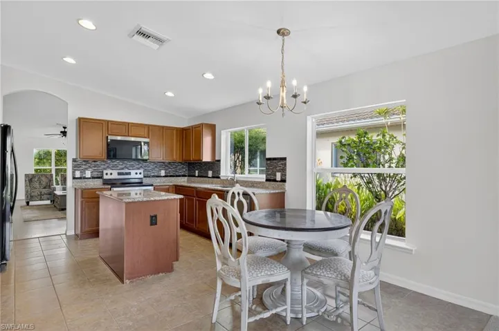 Kitchen with a kitchen island, recessed lighting, vaulted ceiling, healthy amount of natural light, and stainless steel appliances