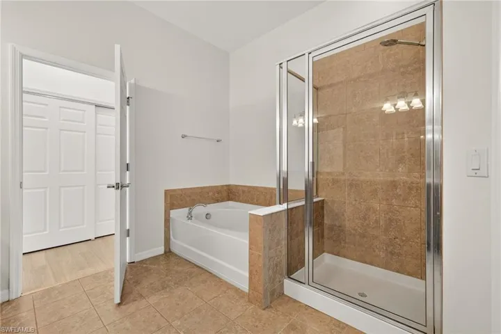 Full bathroom with a bath, a shower stall, and tile patterned floors