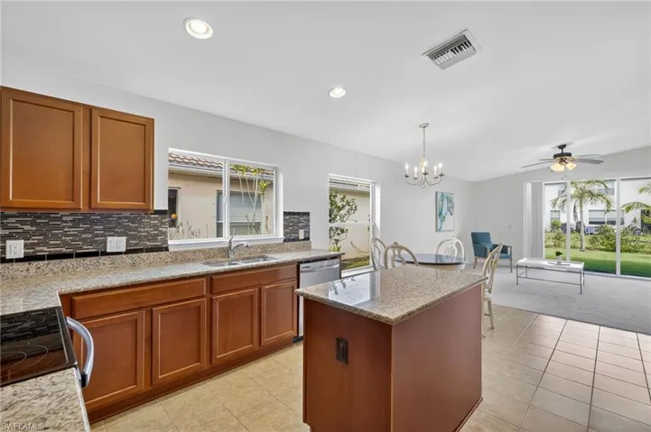 Kitchen with brown cabinets, range, recessed lighting, tasteful backsplash, and a kitchen island