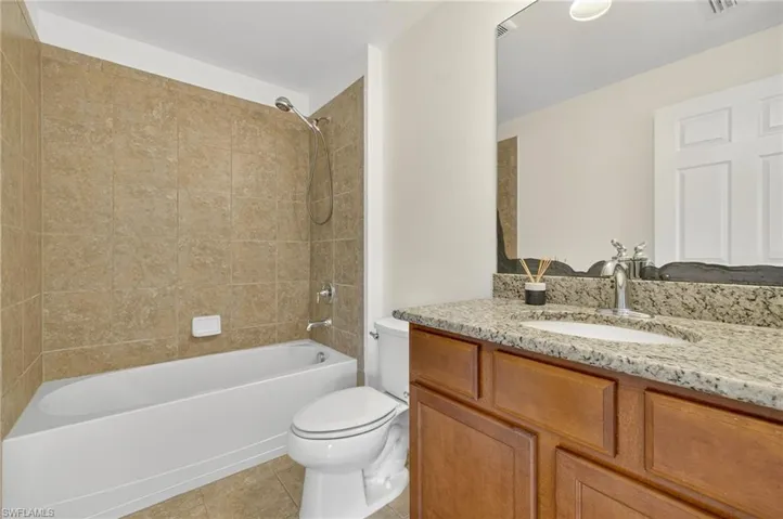 Full bathroom with tub / shower combination, vanity, and tile patterned floors
