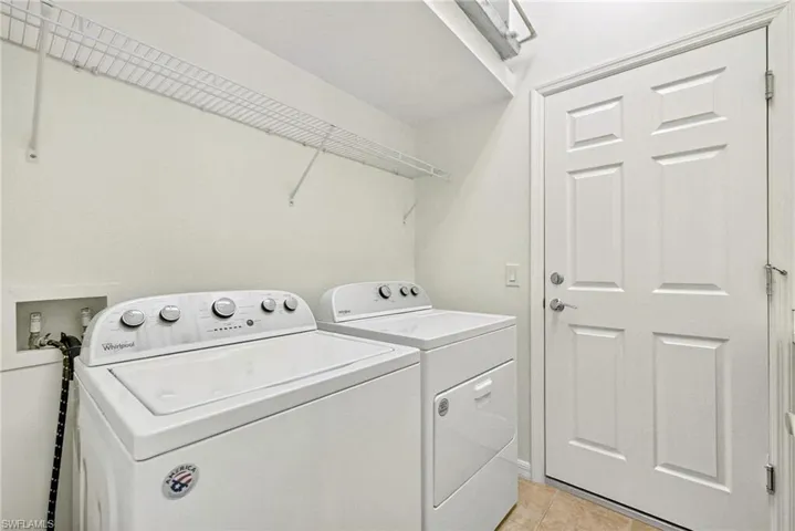 Laundry room featuring washer and dryer and light tile patterned flooring