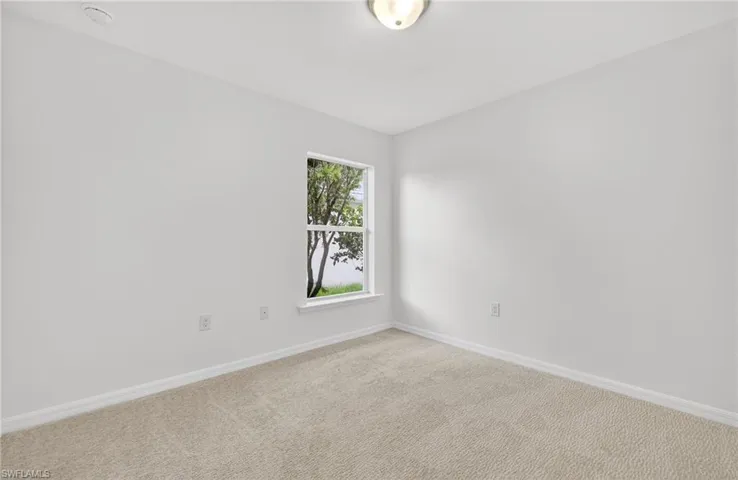 Unfurnished room with baseboards and light carpet