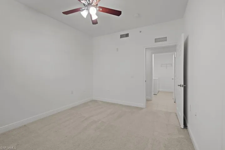 Unfurnished room featuring baseboards, visible vents, ceiling fan, and light colored carpet