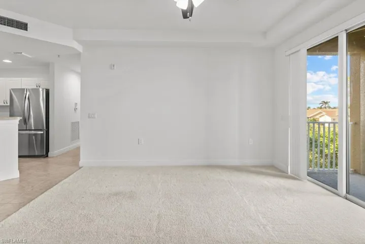 Spare room with light carpet, visible vents, and baseboards
