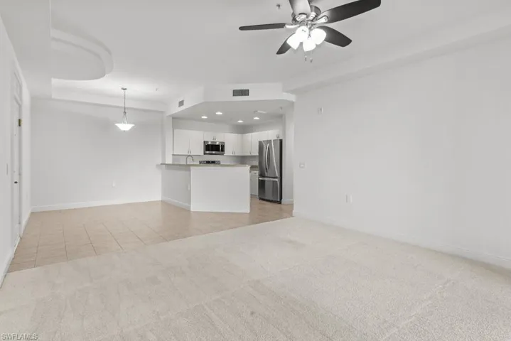 Unfurnished living room with light tile patterned floors, recessed lighting, light colored carpet, visible vents, and baseboards