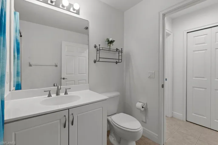 Full bathroom featuring baseboards, vanity, toilet, and tile patterned floors