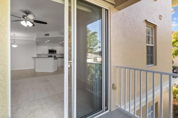 Property entrance with visible vents, a balcony, and stucco siding