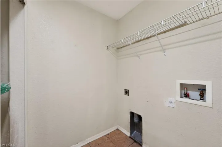 Utility room featuring a wire shelving unit, appliance hookups, and a neutral wall finish