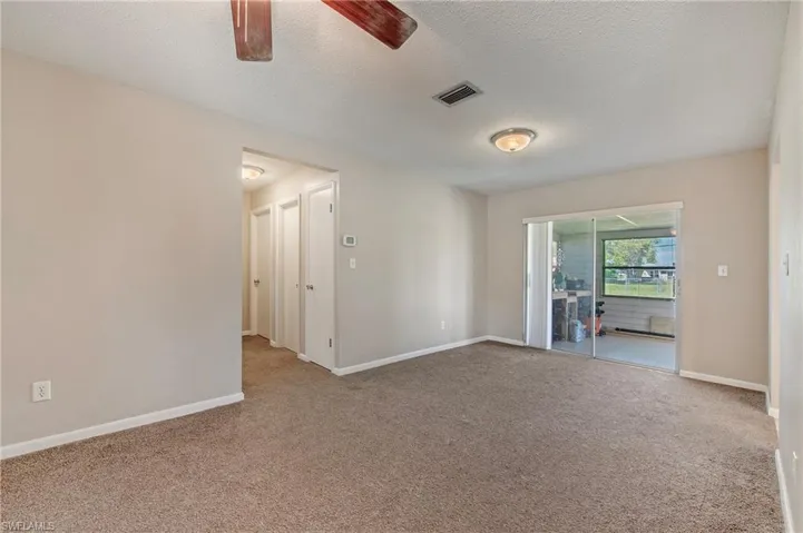 Carpeted spare room featuring ceiling fan and a textured ceiling