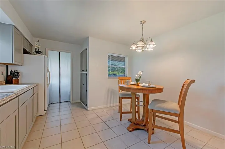 Dining area with a chandelier and light tile floors
