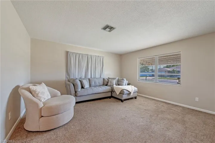 Living room with carpet and a textured ceiling