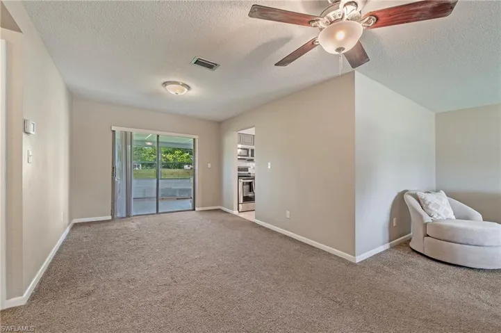 Unfurnished room with carpet, ceiling fan, and a textured ceiling
