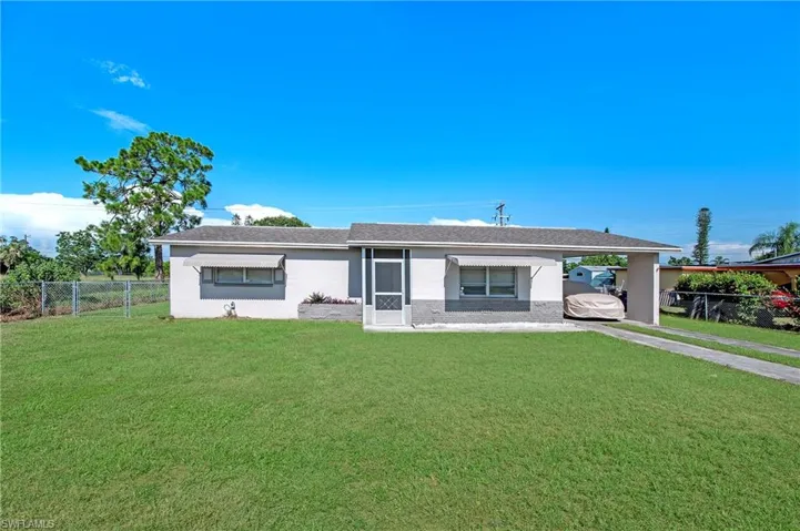 Ranch-style home featuring a front lawn