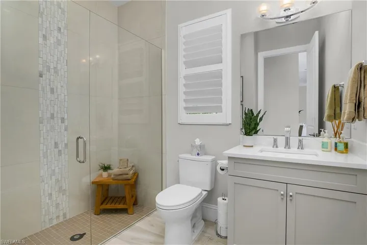 Guest and Pool bath featuring custom tiled shower with frameless glass.
