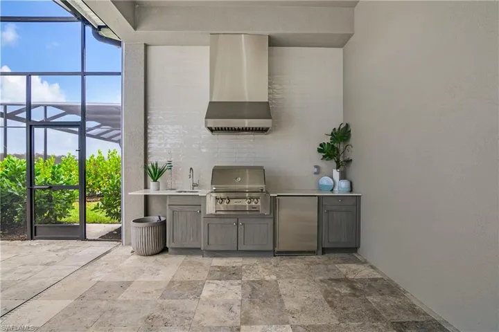 View of patio / terrace with glass enclosure, exterior kitchen, sink, and grilling area