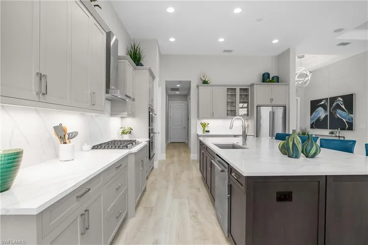 Chef inspired kitchen with oversize island, Natural Gas cooktop, professional grade appliances, beverage cooler, and accent island.