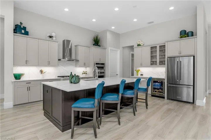 Oversized island, walk in pantry with custom shelving, custom cabinetry, kitchen aid appliances, and a natural gas stove!